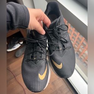 Black and gold Nike running shoes, size 7.5
